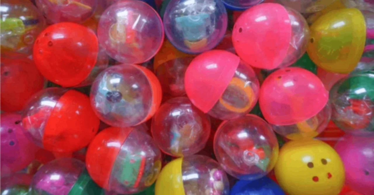 Close-up view of colorful plastic gacha capsules filled with tiny toys.