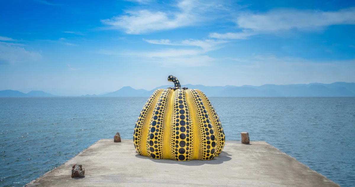 Yayoi Kusama’s large yellow pumpkin sculpture with black dots at the end of a pier in the Seto Inland Sea.